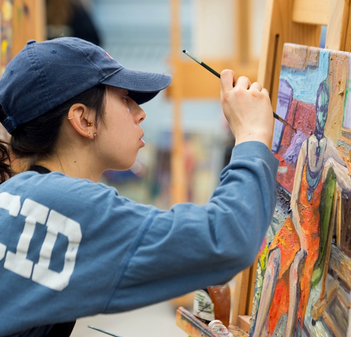 Student painting at an easel